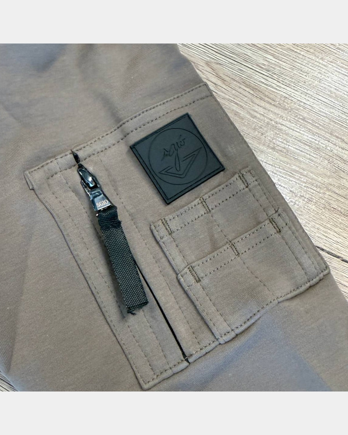 Poche de manche du sweat Ange maquis, zip à tirette noire, écusson en caoutchouc noir et petite poche à stylo